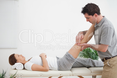 Physiotherapist massaging a leg while placing it on his shoulder