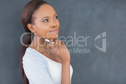 Thoughtful black woman holding a chalk