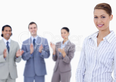 Close-up of a woman smiling with business people applauding whil