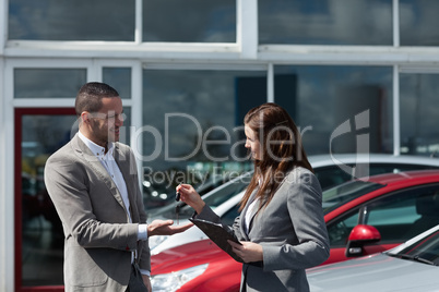 Businesswoman giving car keys to a client