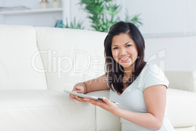 Woman sitting on the floor while holding a tactile tablet