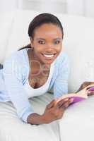 Black woman lying on front while looking at camera