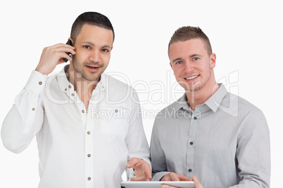 Smiling men holding a phone and a tablet computer