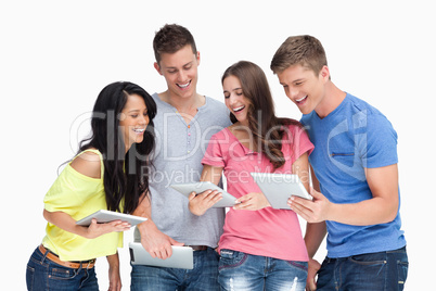 A laughing group of friends looking at their tablet pc's