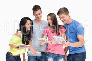 A laughing group of friends looking at their tablet pc's