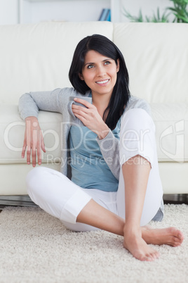 Woman sitting on the floor while holding a grey mug