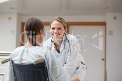 Smiling doctor in front of a patient on a wheelchair