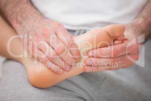Podiatrist massaging the foot of a woman while holding it on his