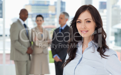 Businesswoman smiling and standing in a bright room with her tea