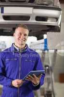 Smiling mechanic holding a tablet computer
