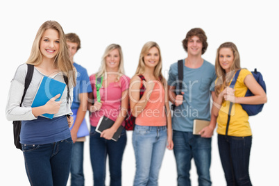 A smiling girl standing in front of her friends