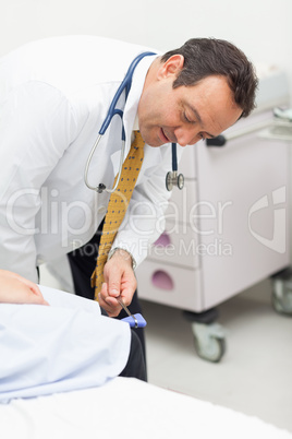 Doctor checking the reflexes of the knee of a patient
