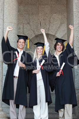 Happy graduates raising arm