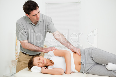 Serious practitioner massaging a peaceful woman