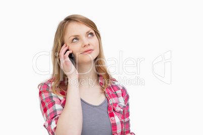 Woman looking up while holding a mobile phone