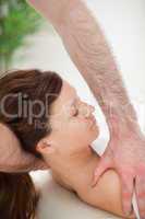 Therapist manipulating the neck of his patient while holding her