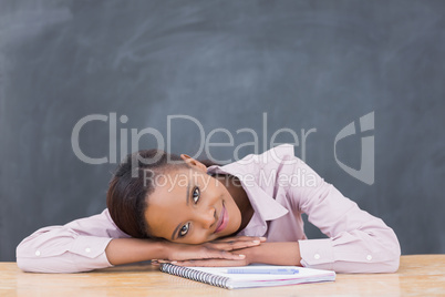 Black woman leaning her head on desk while smiling