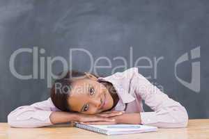 Black woman leaning her head on desk while smiling