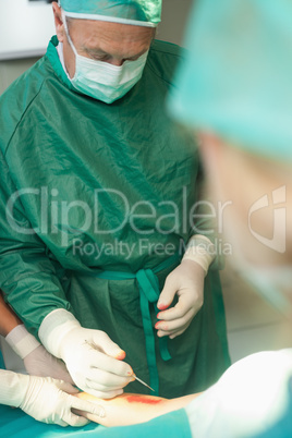 Surgeon using a scalpel to cut the skin of a patient