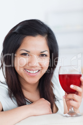 Close-up of a smiling woman holding a glass of red wine
