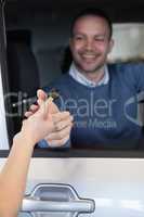 Man in a car receiving a key