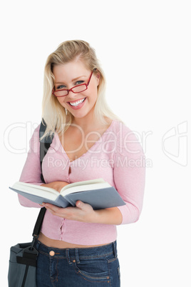 Woman beaming while holding an interesting novel