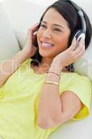 Close-up of a smiling Latino listening music on a smartphone