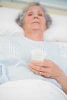 Elderly patient holding a plastic glass in her hand