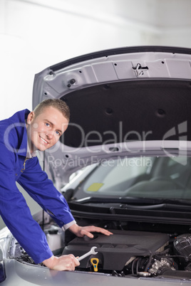 Smiling mechanic holding a spanner