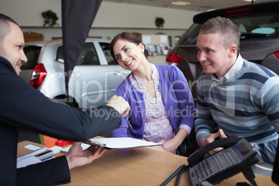 Couple chatting with a car salesman