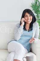Woman talking on the phone while sitting on a couch