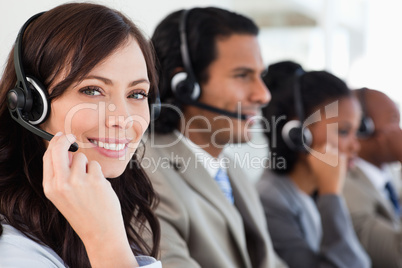Smiling employee working with a headset while looking at the cam