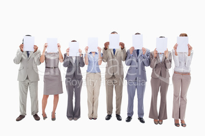 Business people hiding their faces with support for letters