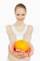 Close up of a woman presenting a tangerine