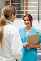 Smiling nurse talking to a doctor