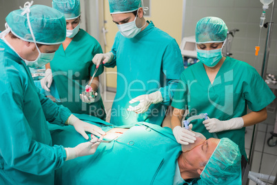 Surgeon giving surgical tool to a nurse