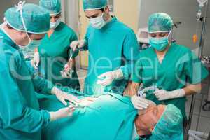 Surgeon giving surgical tool to a nurse