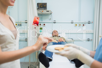 Nurse giving biscuits to a patient