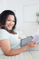 Woman smiling while holding a card and a tactile tablet