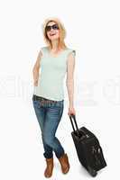 Young woman smiling while holding a suitcase