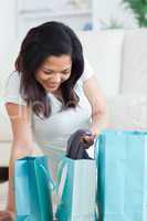 Smiling woman holding clothes from a shopping bag