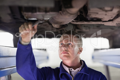 Mechanic repairing a car with a spanner