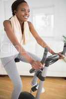 Black woman doing sport on an exercise bike