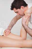 Chiropractor manipulating the leg of his patient while folding i