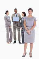 Woman holding her hands with co-workers talking in the backgroun