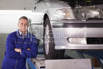 Front view of a smiling mechanic with arms crossed