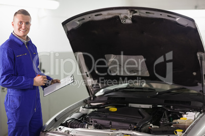 Smiling mechanic holding a clipboard Smiling mechanic holding a clipboard
