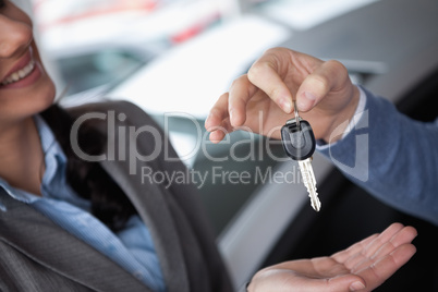 Smiling woman receiving keys from someone