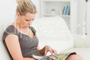 Woman sitting while reading a magazine