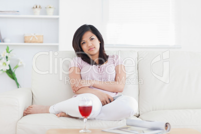 Woman sitting on a couch while crossing her arms
